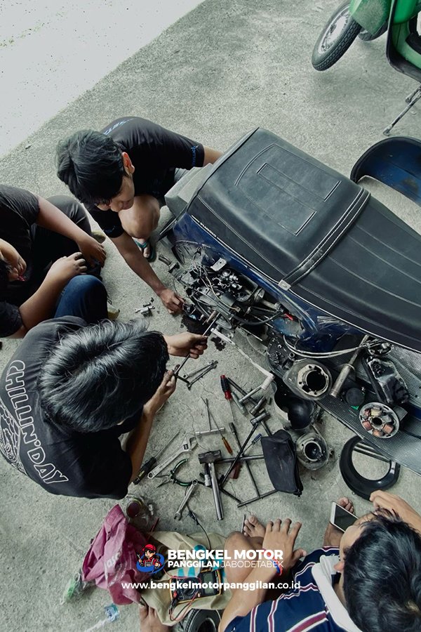 Montir membantu servis Vespa